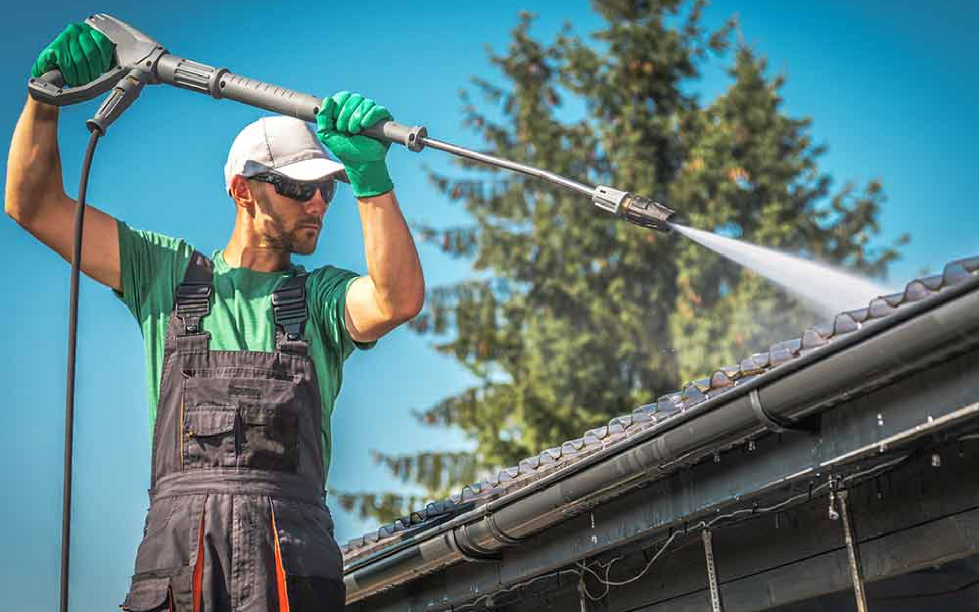 Professional cleaner power washing eavestrough